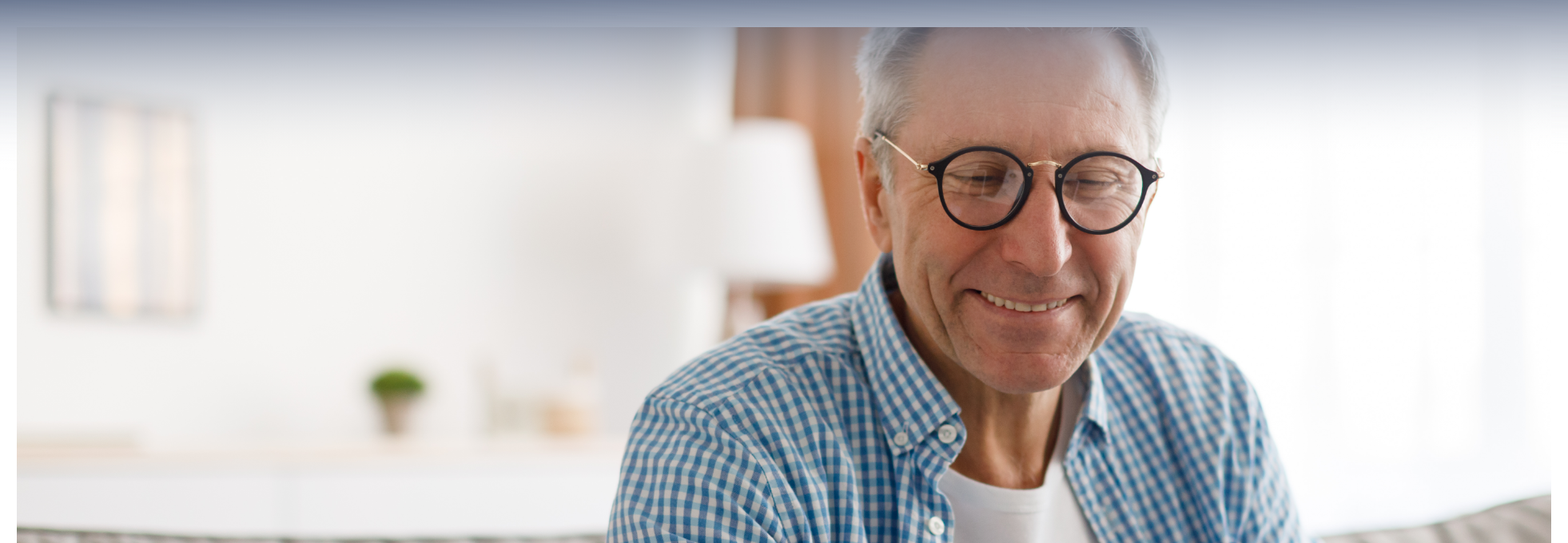 Image d’un homme souriant en chemise et portant des lunettes
